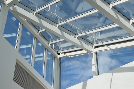 a white building with a glass roof and sky in the background