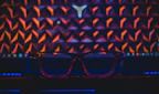 A bold, colorful pair of eyeglasses on a vibrant patterned fabric.