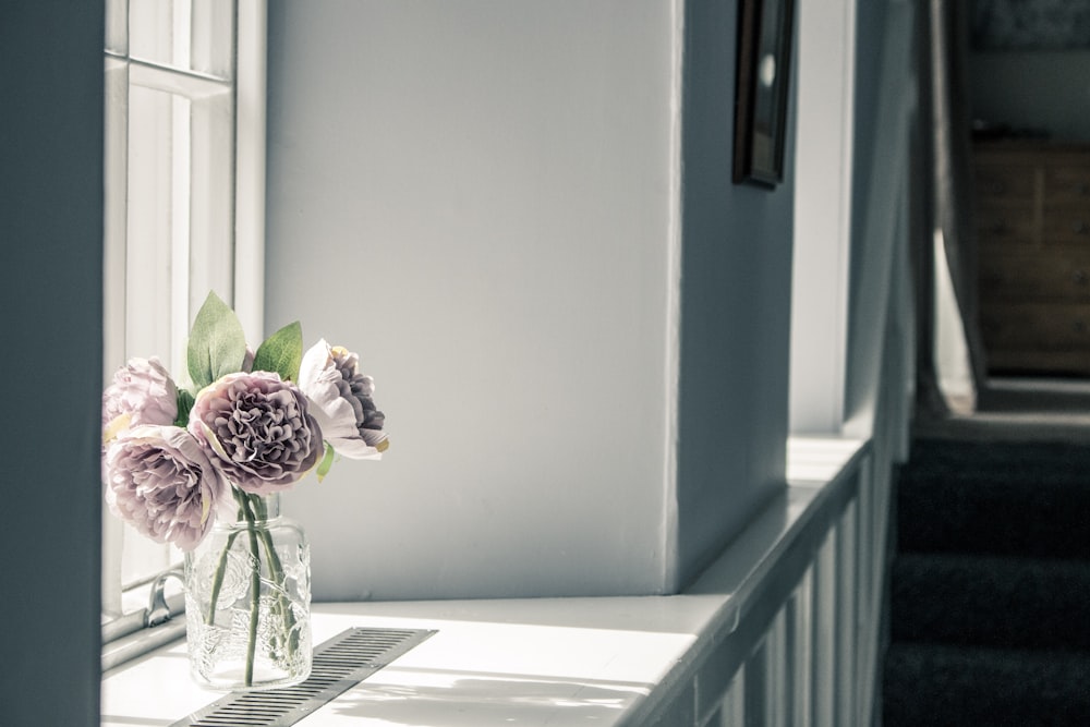 purple flowers in clear glass vase