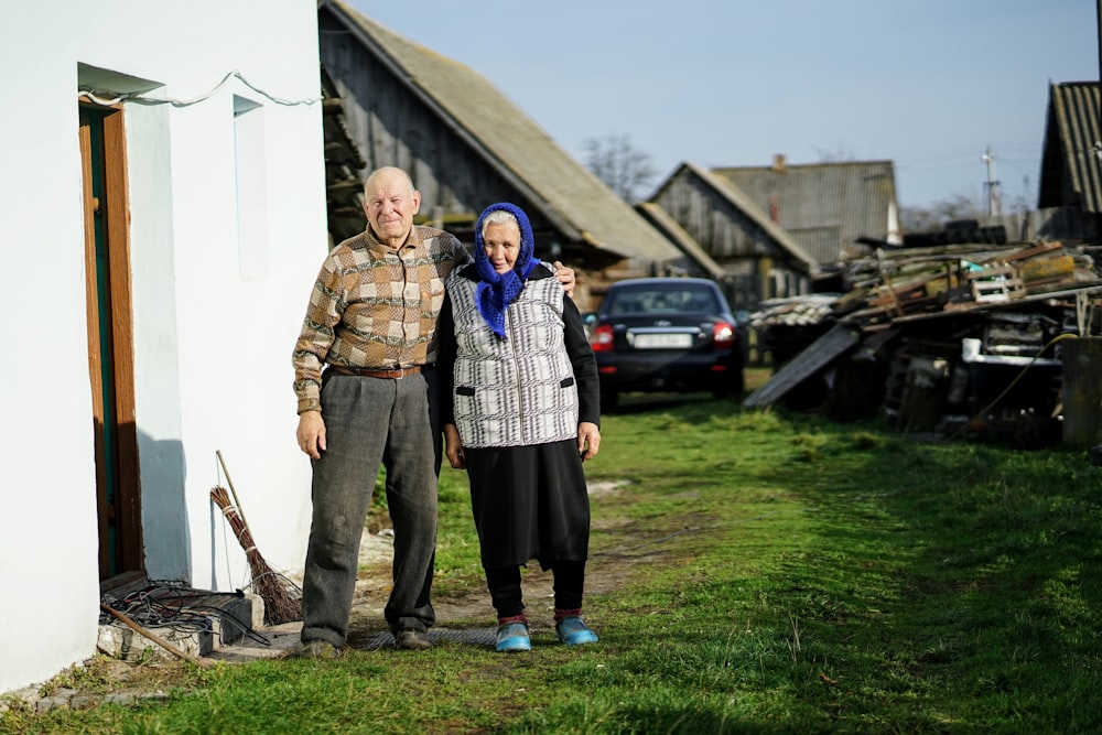 man and woman standing beside building and near cars