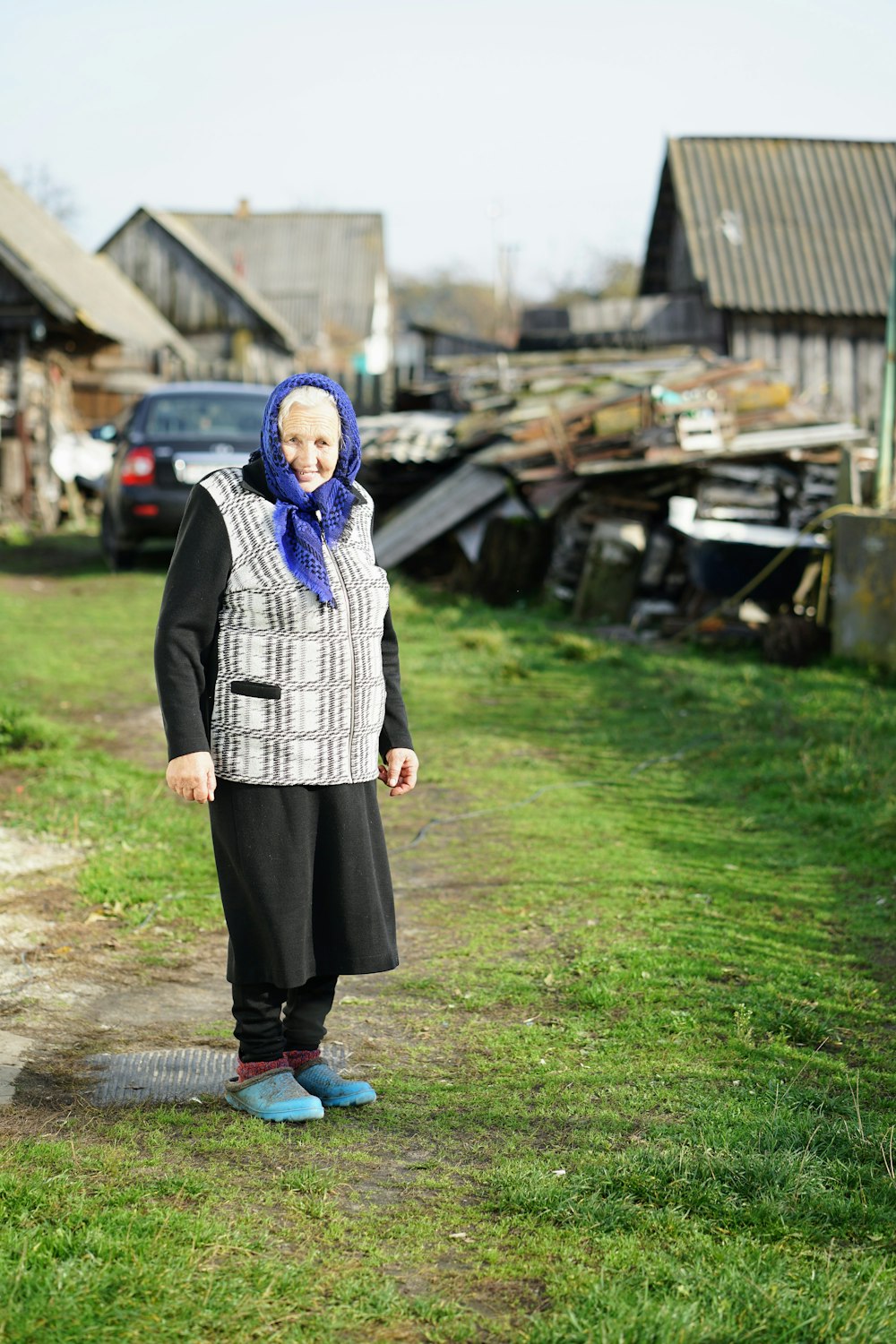 smiling elderly woman in black long sleeved dress and grey and white vest