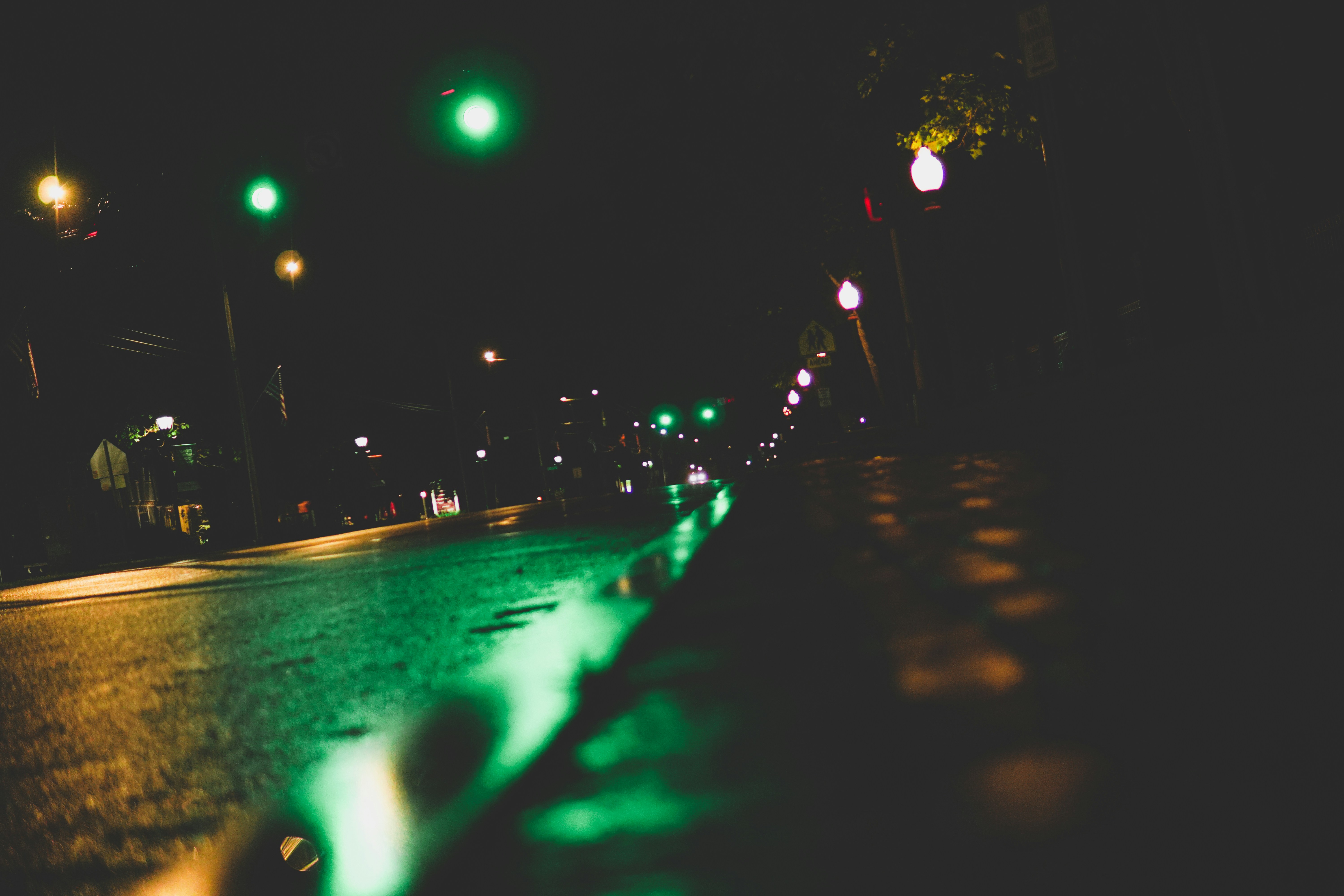 a city street at night with green lights, 