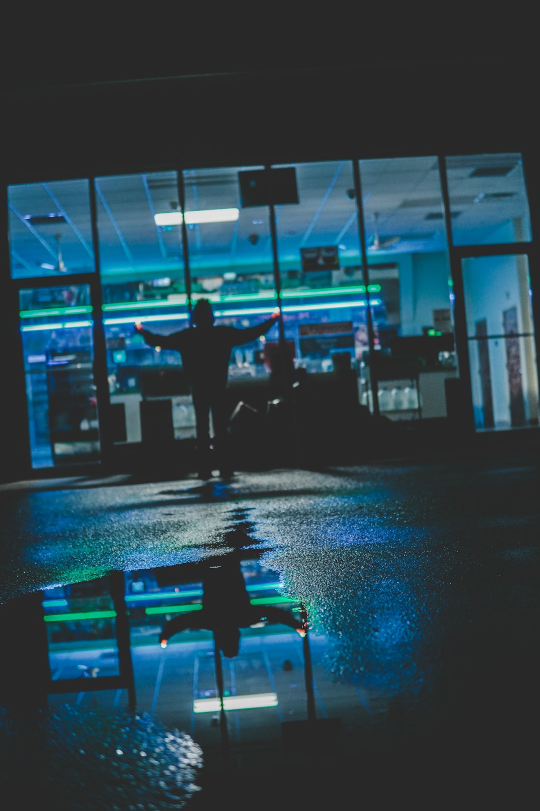 silhouette of person standing in front of glass store facade