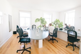 grey wooden table and black leather rolling chairs
