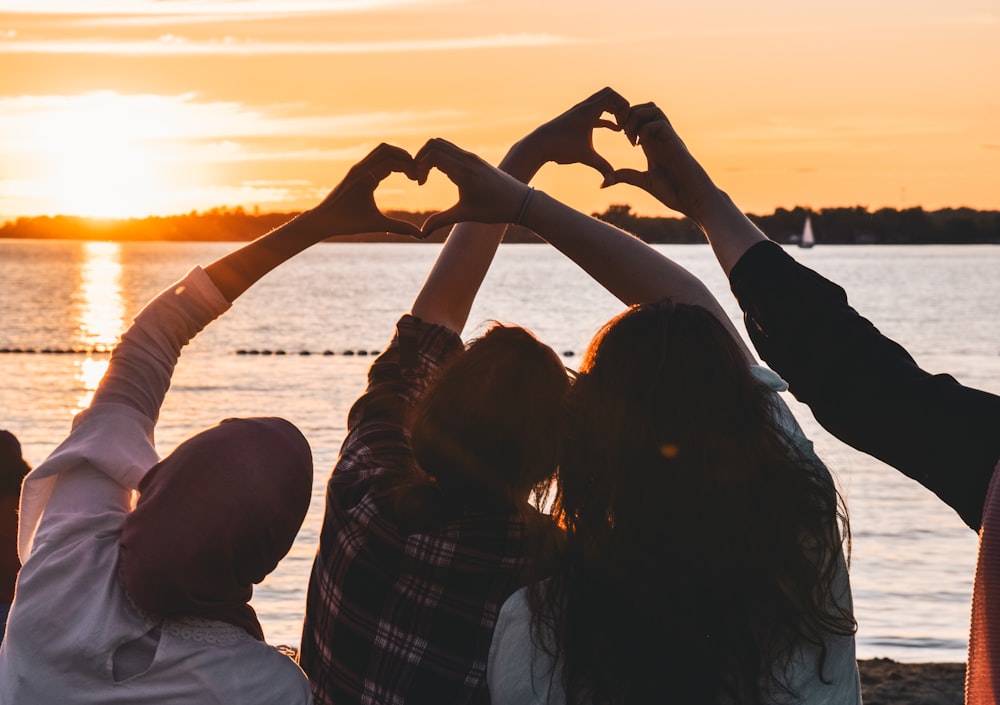 people near body of water during golden hour