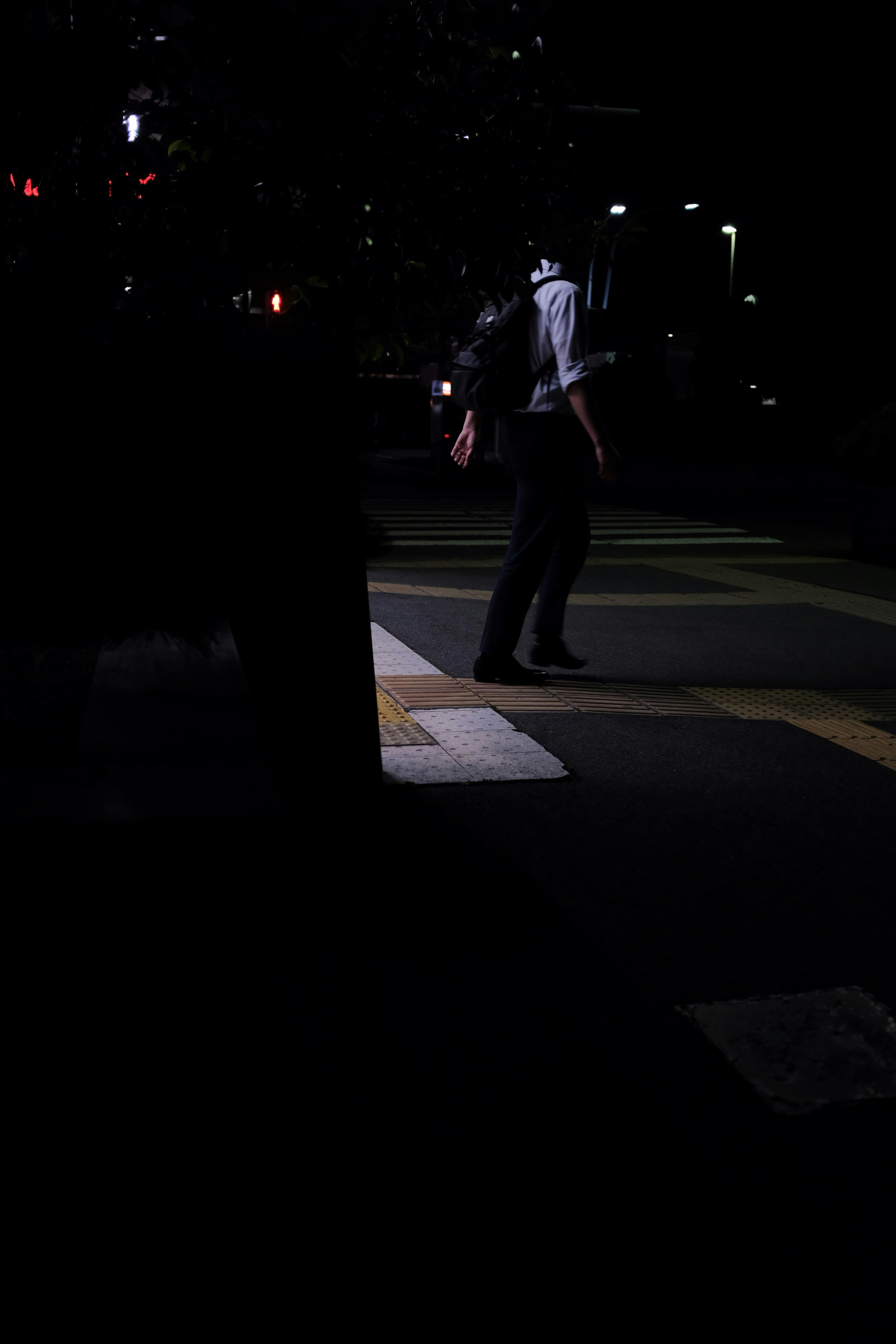 A man walking across a cross walk at night photo – Free City Image on ...