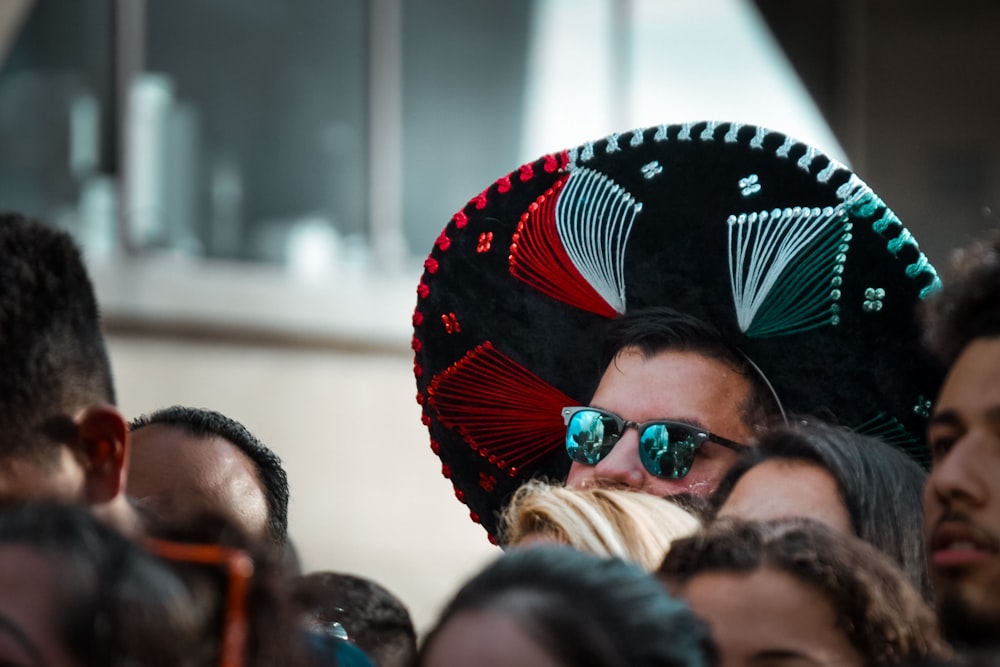 person wearing sunglasses and multicolored hat