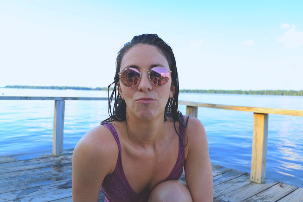 woman on wooden dock near body of water
