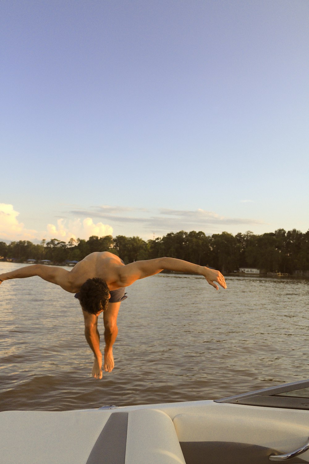 topless man jumping during daytime