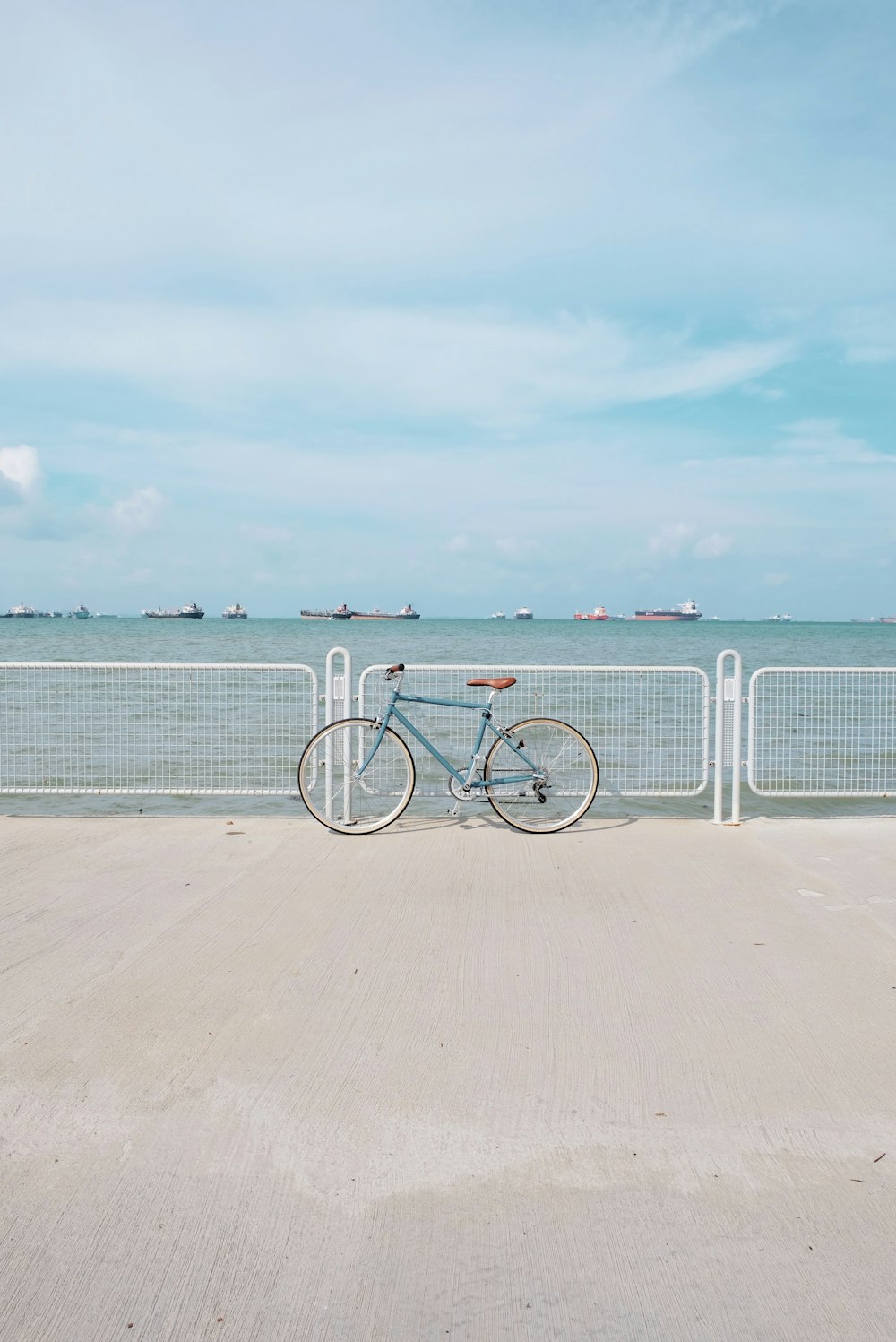 blaues Pendler-Retro-Fahrrad, das sich an ein Dockgeländer lehnt