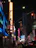 Outdoor LED sign glowing brightly at night in a bustling city street.