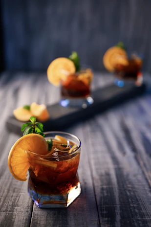 Close-up of a signature cocktail garnished with fresh herbs and citrus slices.