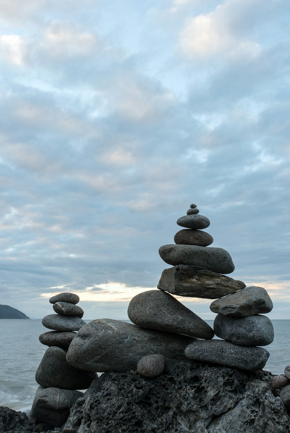 balanced stones on rock beside the ocean