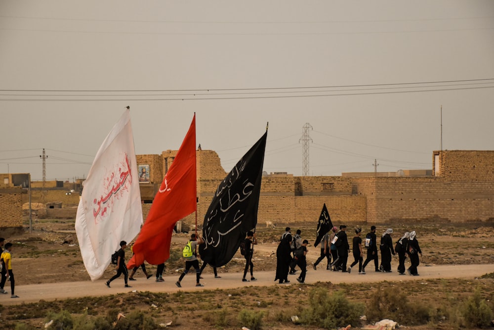 people with white, red and black flags marching in street