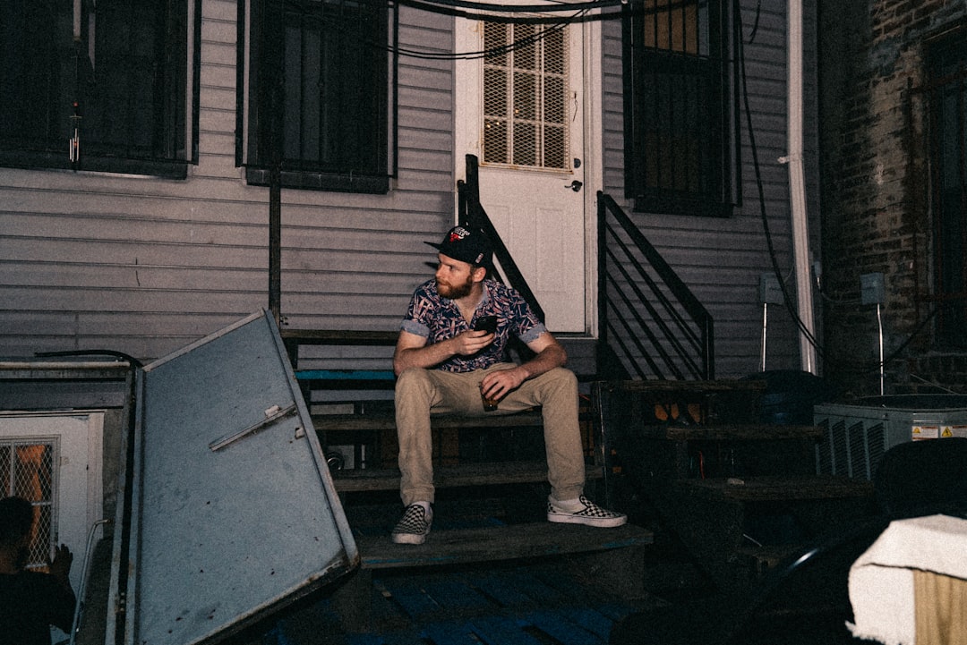 man sitting on stairs of house