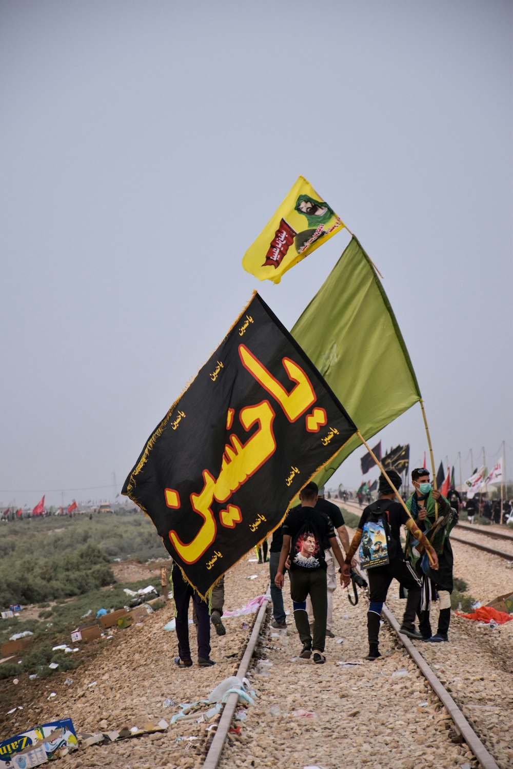 Hommes tenant deux drapeaux vert et noir pendant la journée