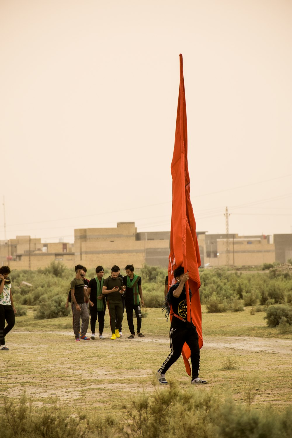 unknown person carrying orange flag outdoors