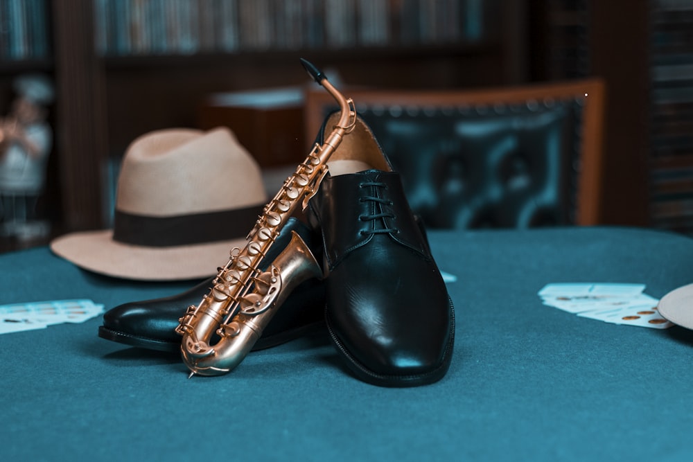 pair of black leather dress shoes and gold saxophone miniature