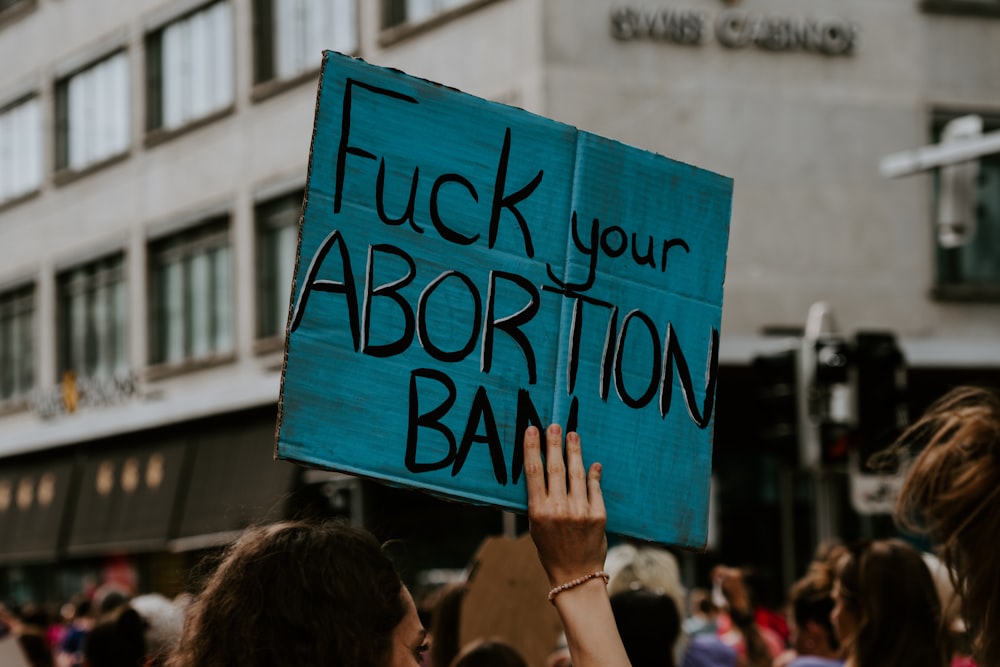 persona que sostiene la pancarta impresa de la prohibición del aborto