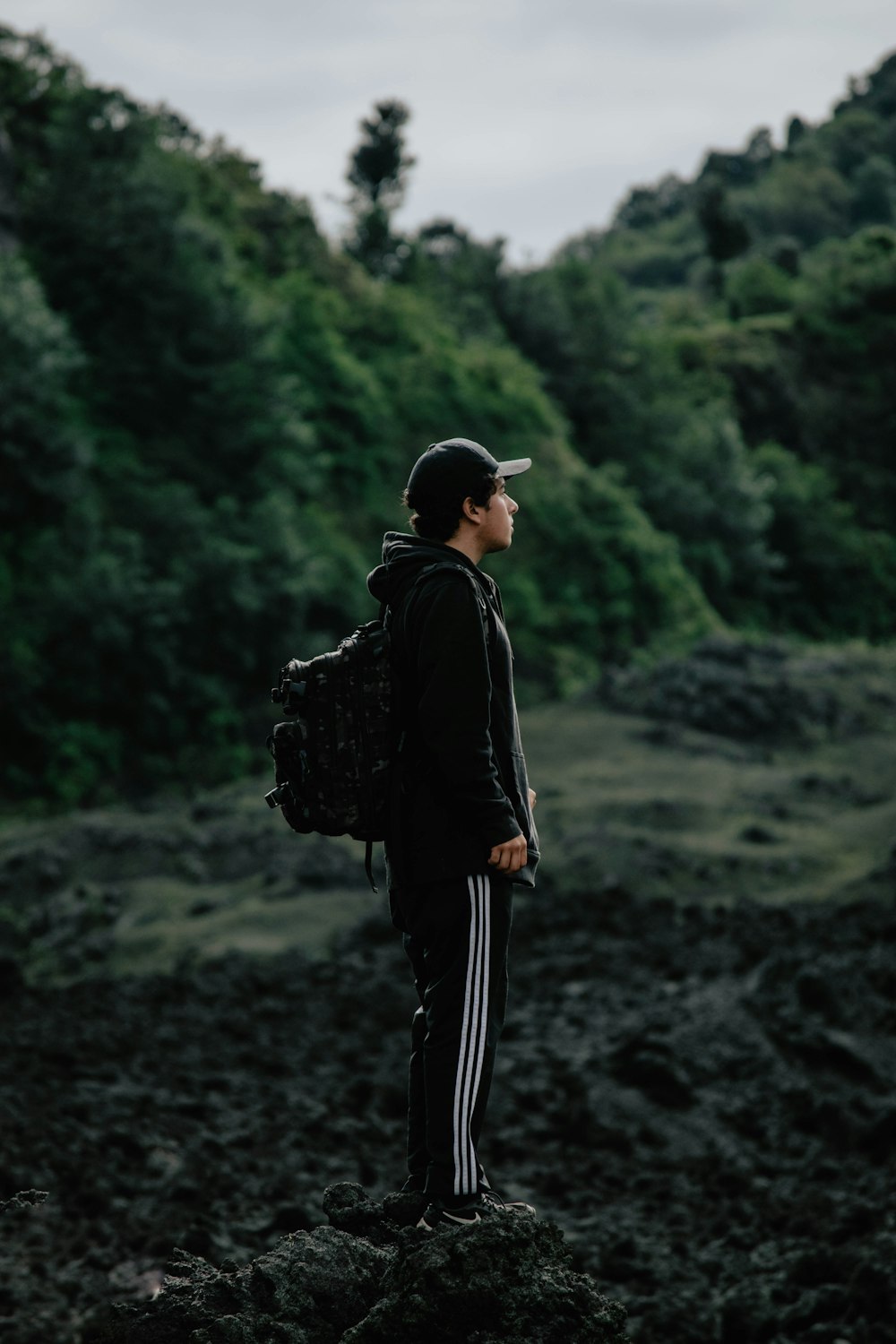 man with backpack standing at the forest