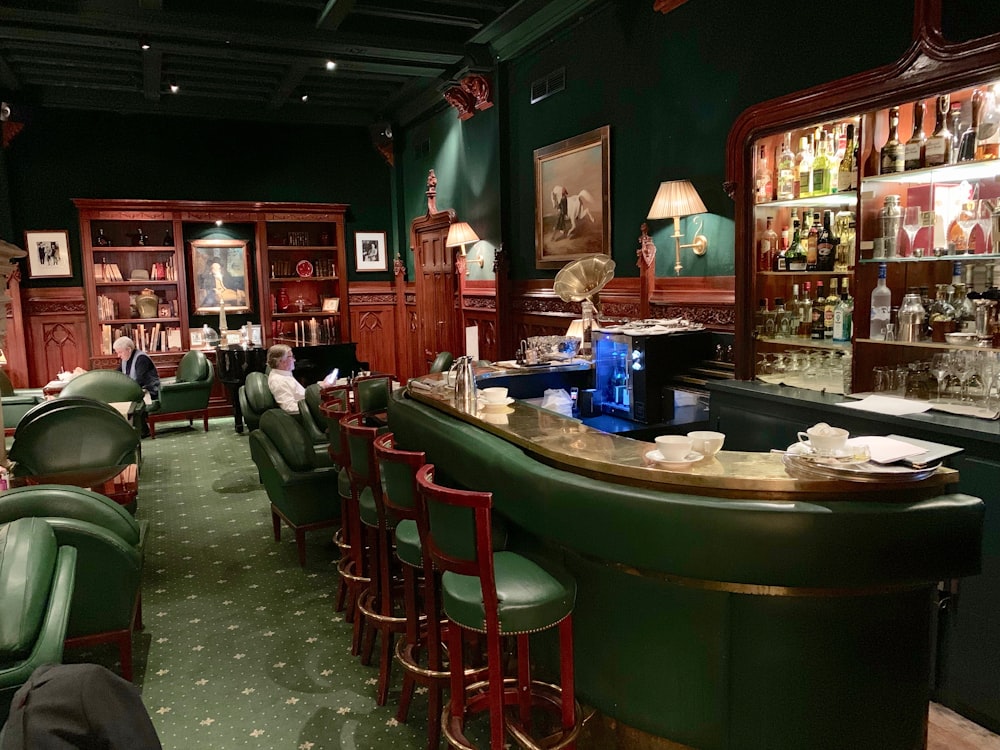 person sitting on green chair inside bar