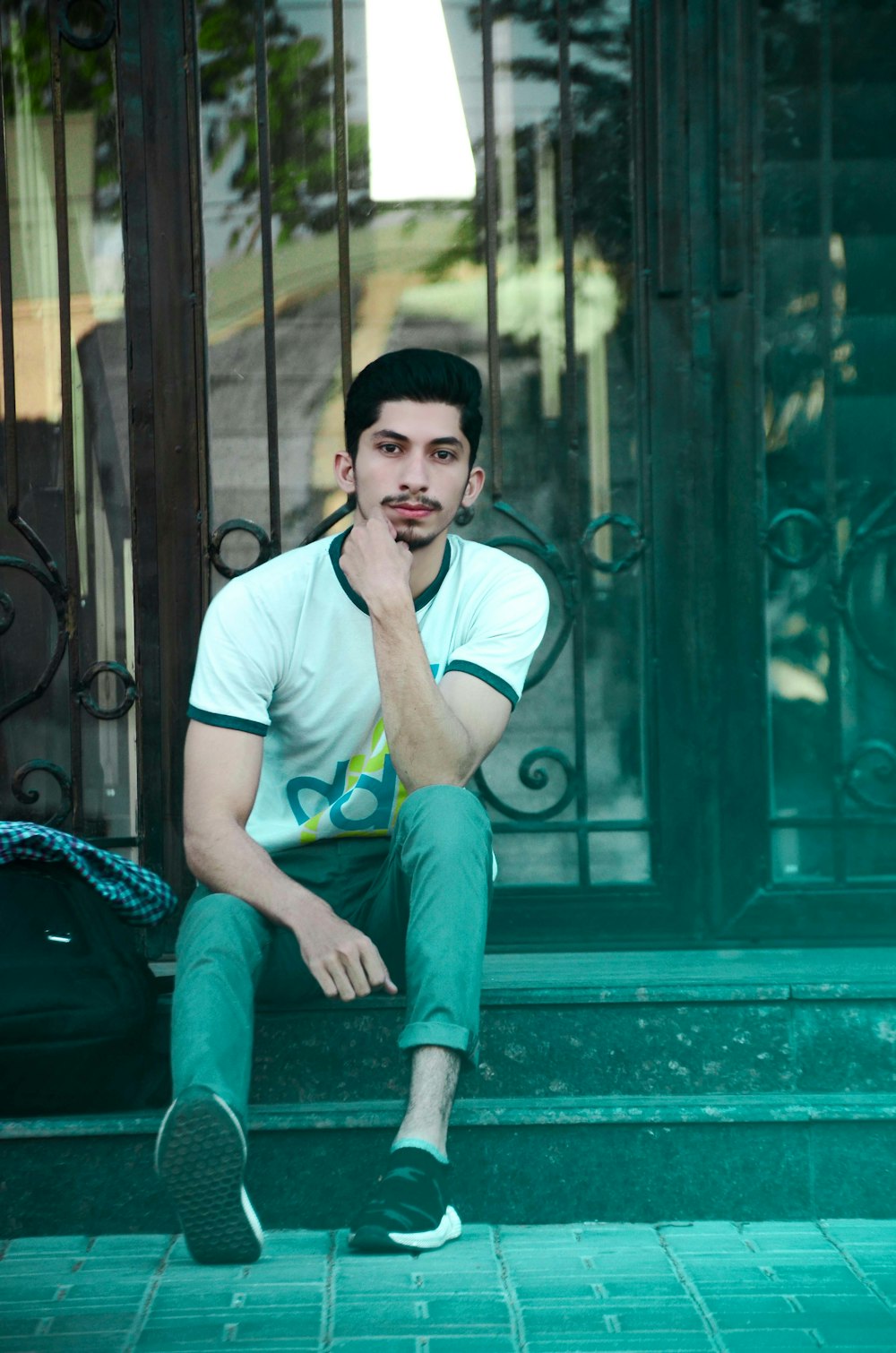 man sitting wearing white and black crew-neck t-shirt