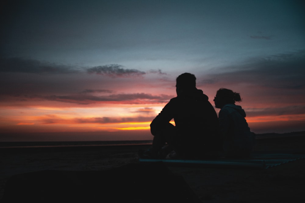 two person sitting during golden hour