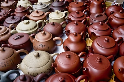 pile of brown and beige teapots melting pot teams background