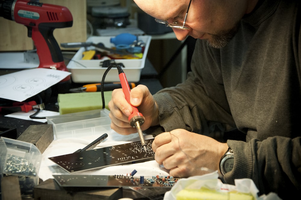 man fixing the device using soldering iron