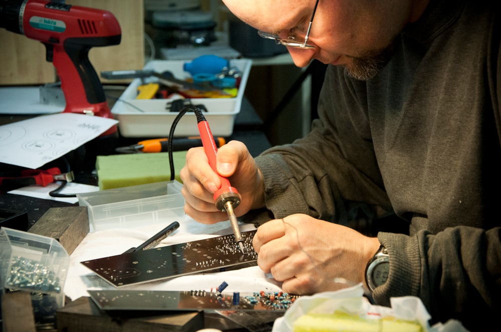 man fixing the device using soldering iron