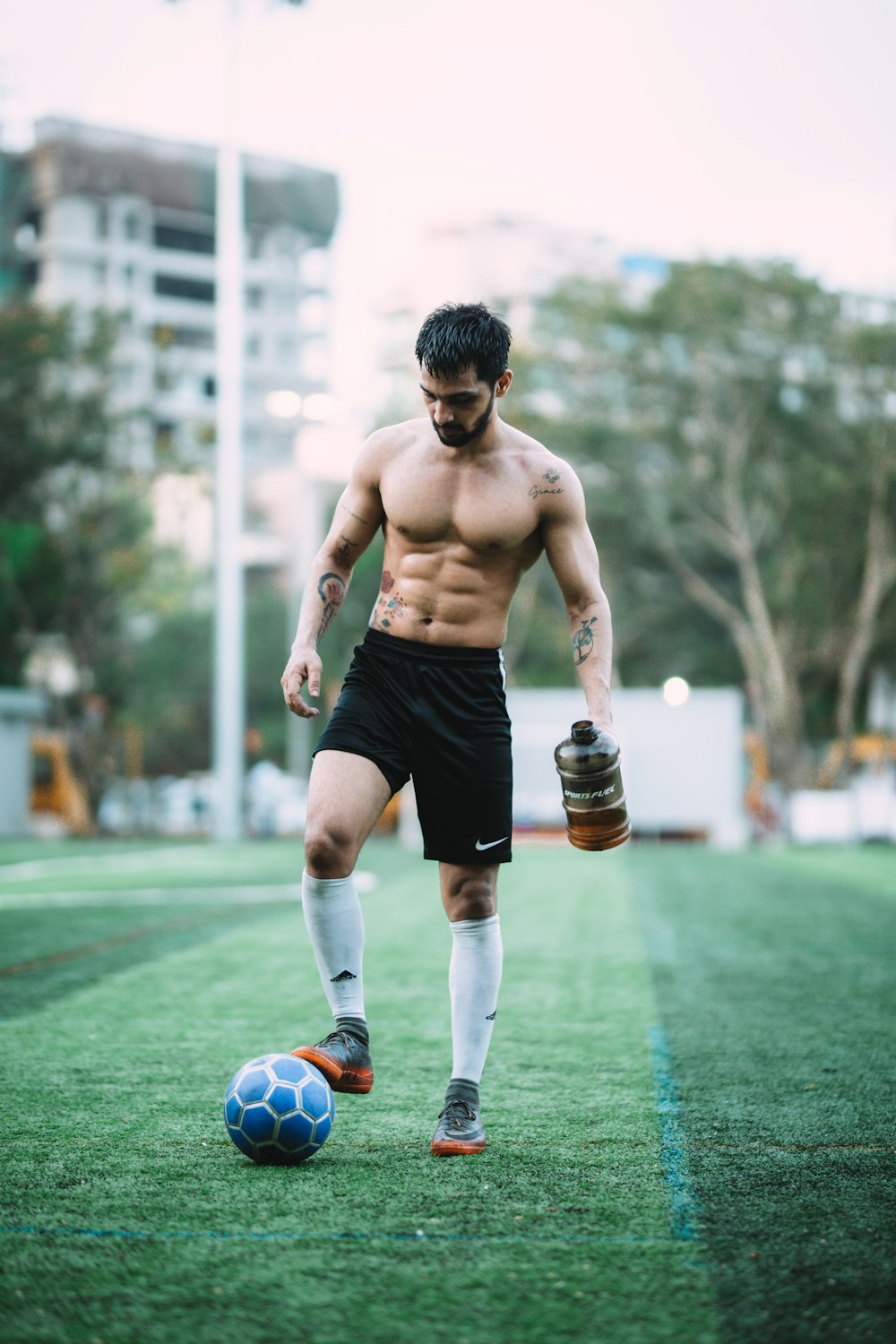 homme jouant au ballon de football pendant la journée