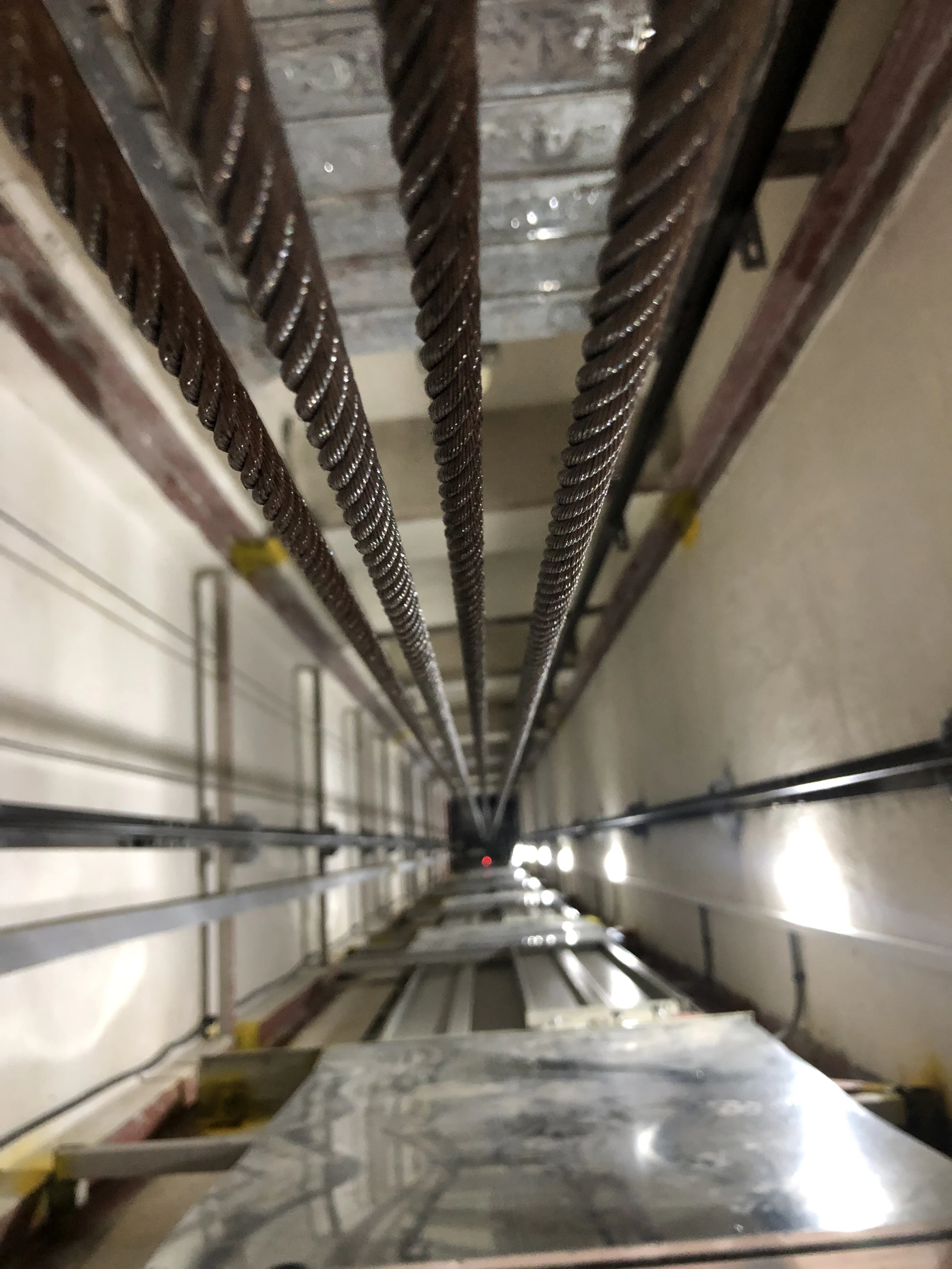a very long hallway with a bunch of wires hanging from the ceiling