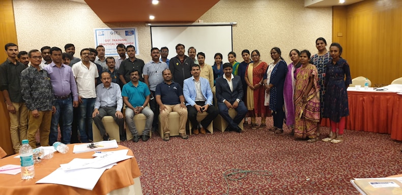 A professional trainer delivering a workshop to an engaged audience in a modern training room.