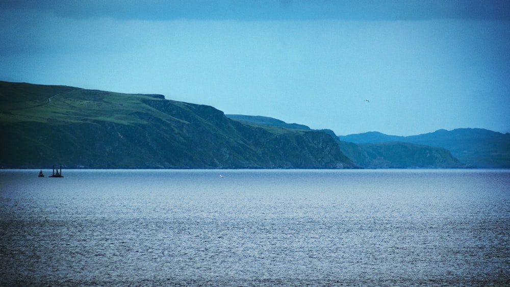 landscape photo of green mountains near body of wate r