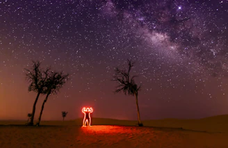 A dramatic night sky with a glowing UFO silhouette hovering above a desert landscape.