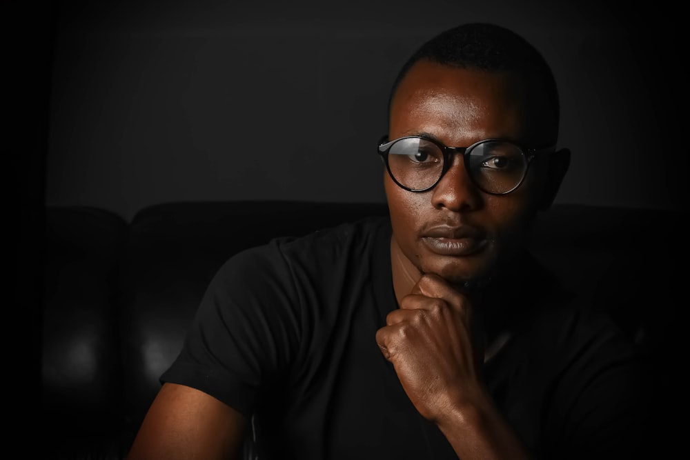 shallow focus photo of man wearing eyeglasses with black frames