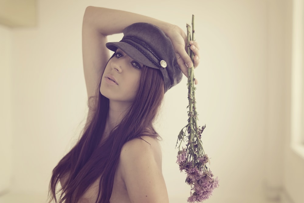 woman holding purple cluster flowers inside room