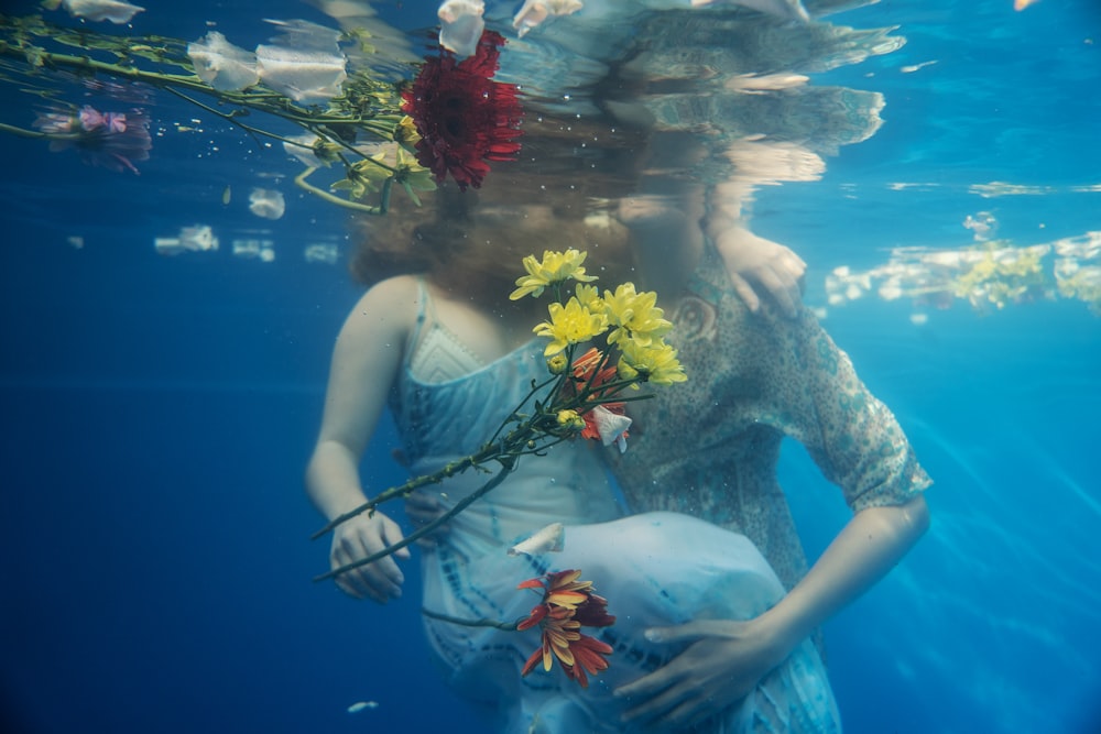 woman holding flower underwater