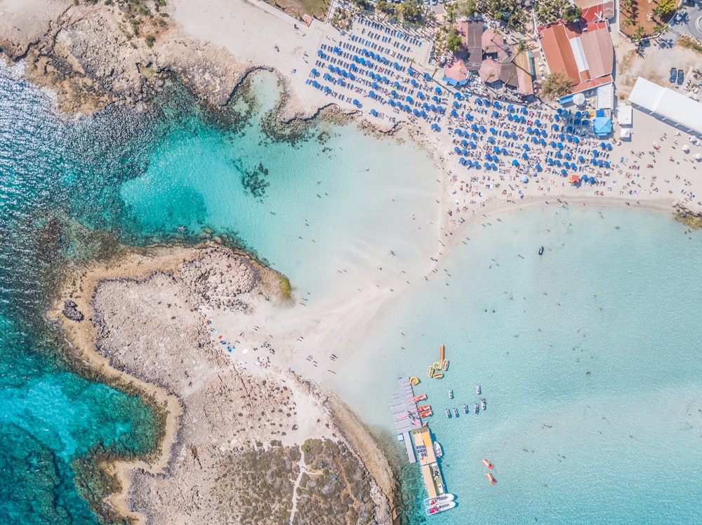 Personas cerca de la orilla del mar y casas de playa con vistas al mar en calma