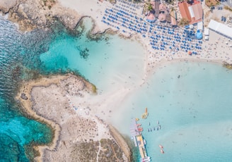 seashore and beach houses with people next to a calm sea