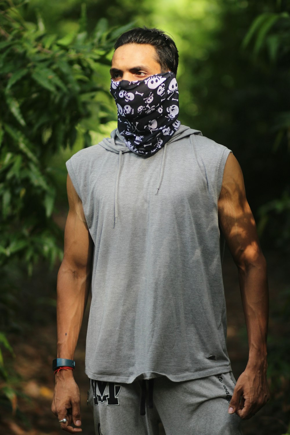 man in grey tank top with face mask standing