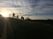 A scenic view of a horse and rider on a trail during sunset.