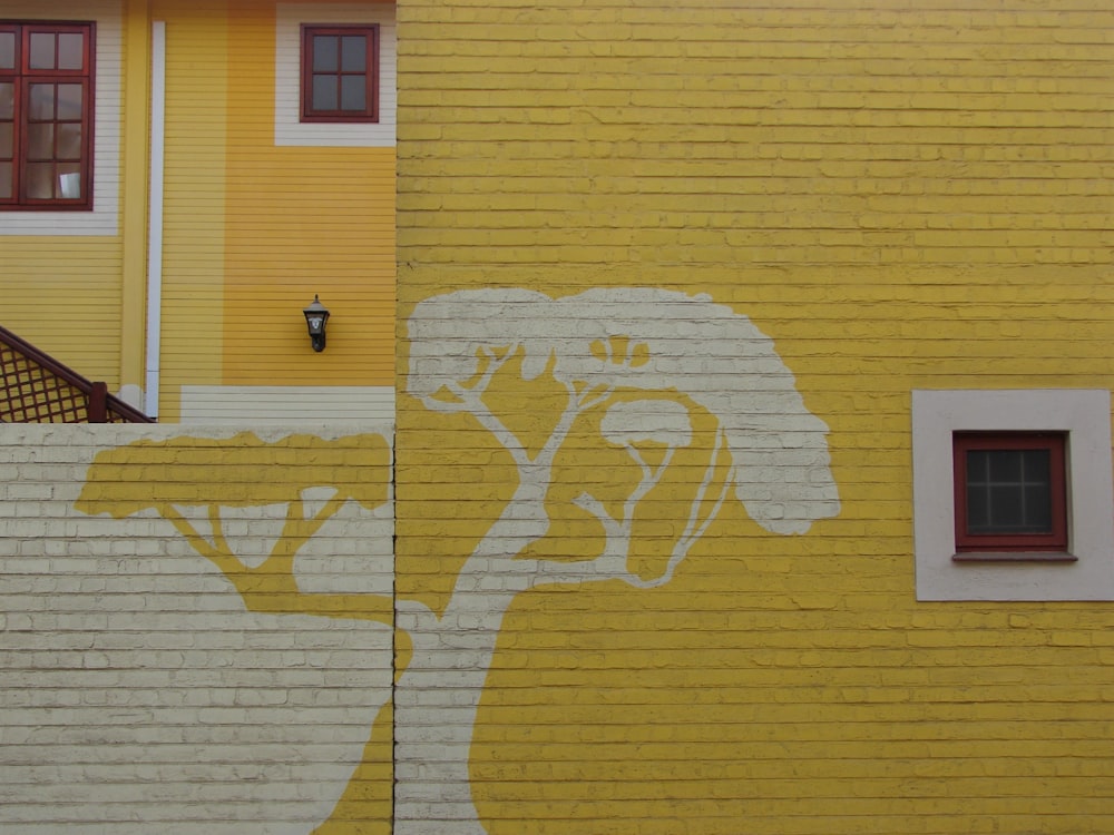 yellow and white tree painting on brick walls