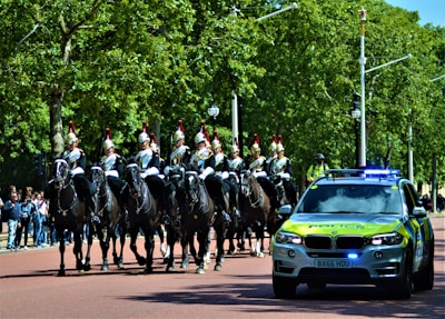 A peaceful procession of riders moving through a snow-dusted village street, with white and gold banners fluttering in the breeze.