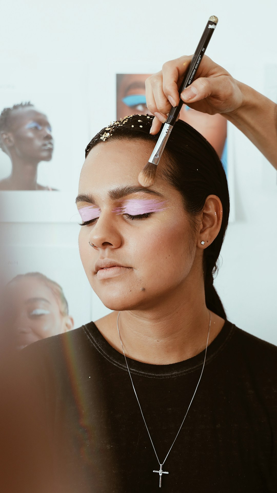 makeup artist applying makeup using brush on woman