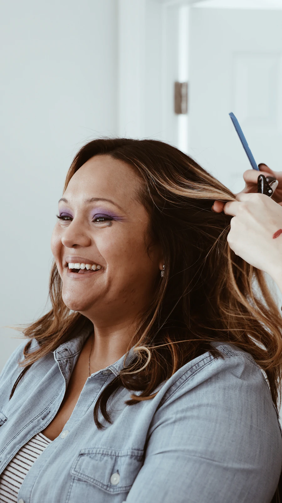 Smiling salon client having her hair styled