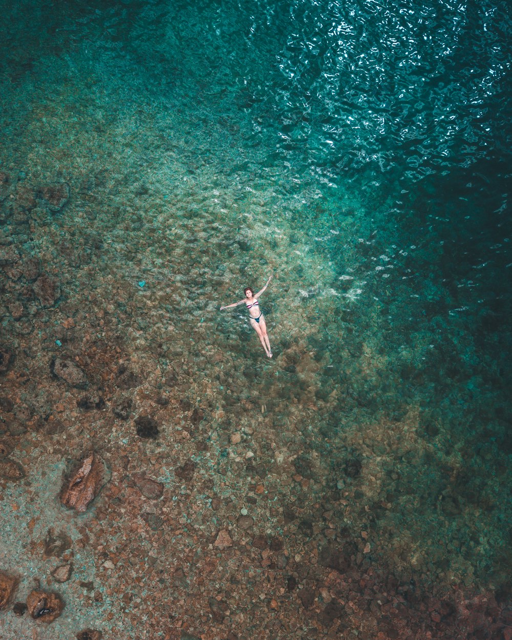 woman floating on water surface aerial photography