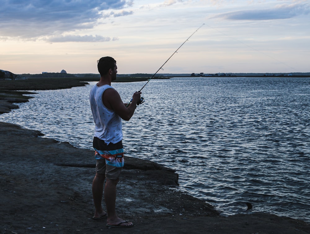 man fishing on rocky shore