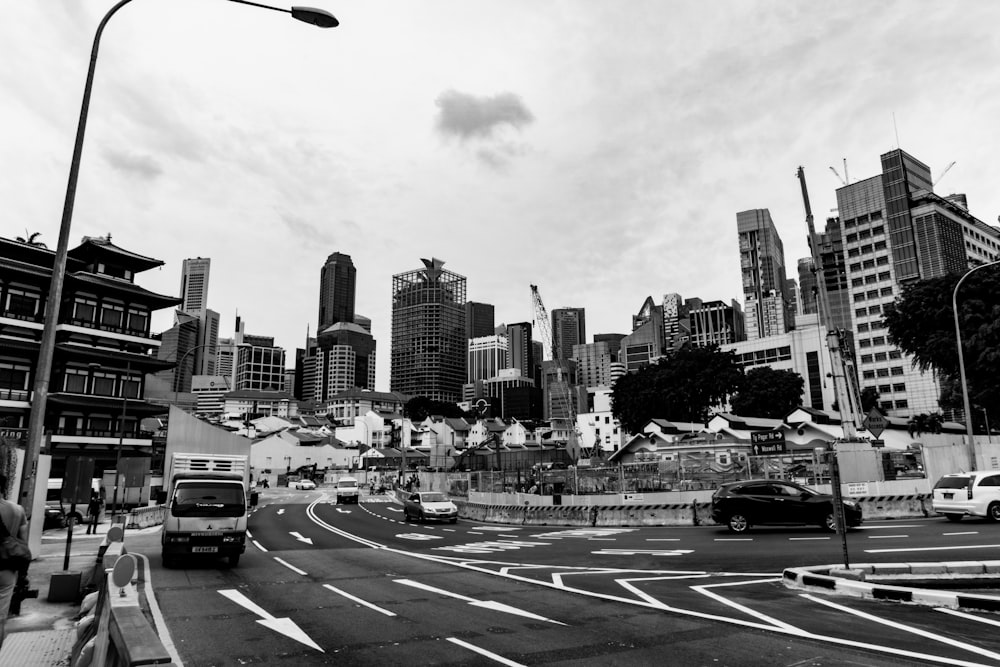 grayscale photography of vehicles on road