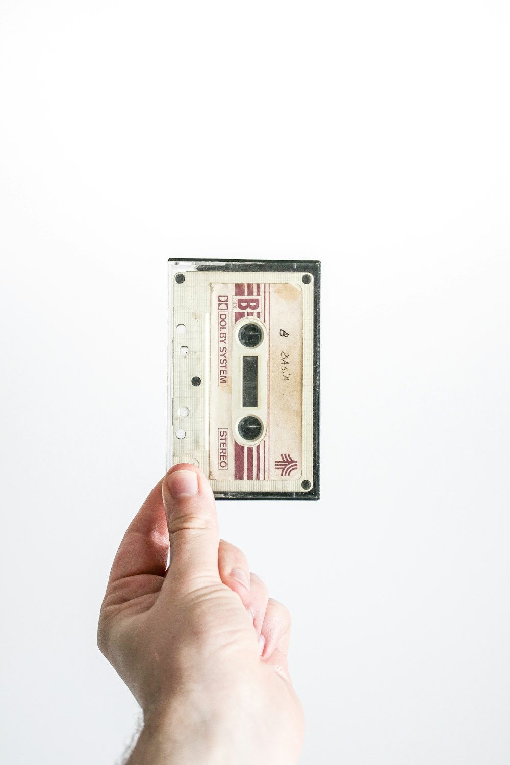 person holding brown cassette tape